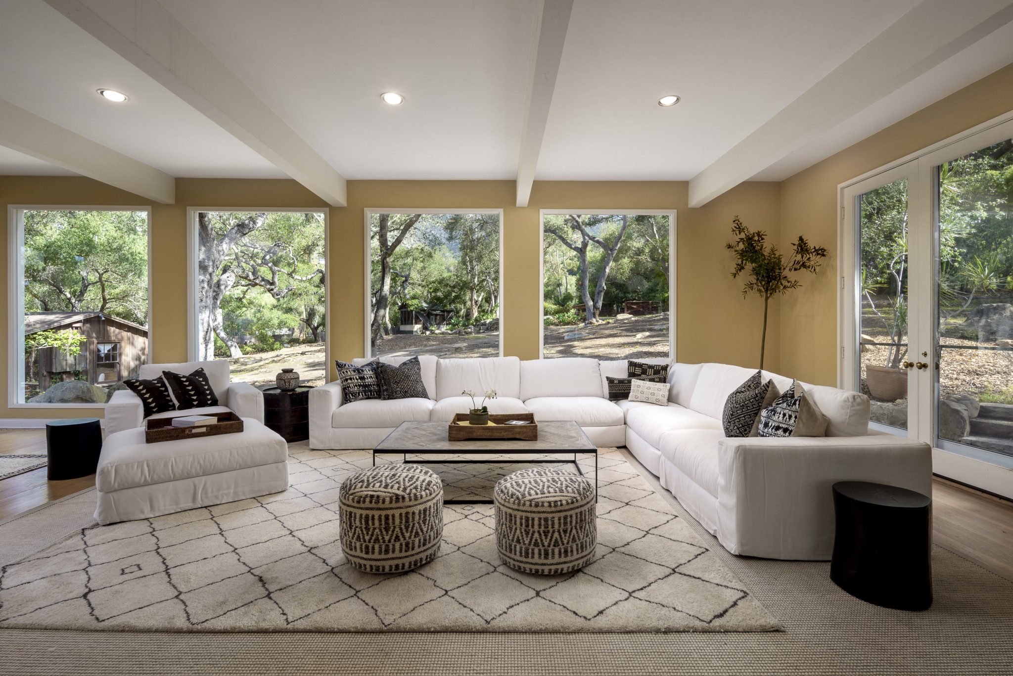 one of the many spacious living areas, framed by romantic oak trees and mountain views.